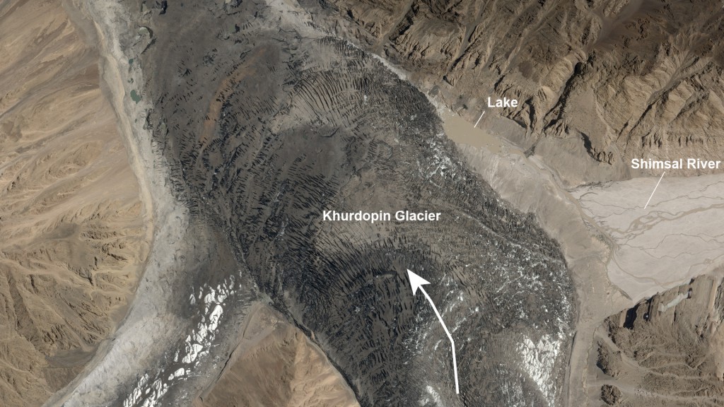 Khurtopin Glacier in Pakistan, seen during August 2017. The arrow shows the direction the glacier is surging, blocking the flow of the river to create the small lake. Image by Planet Labs (CC BY-SA 4.0)