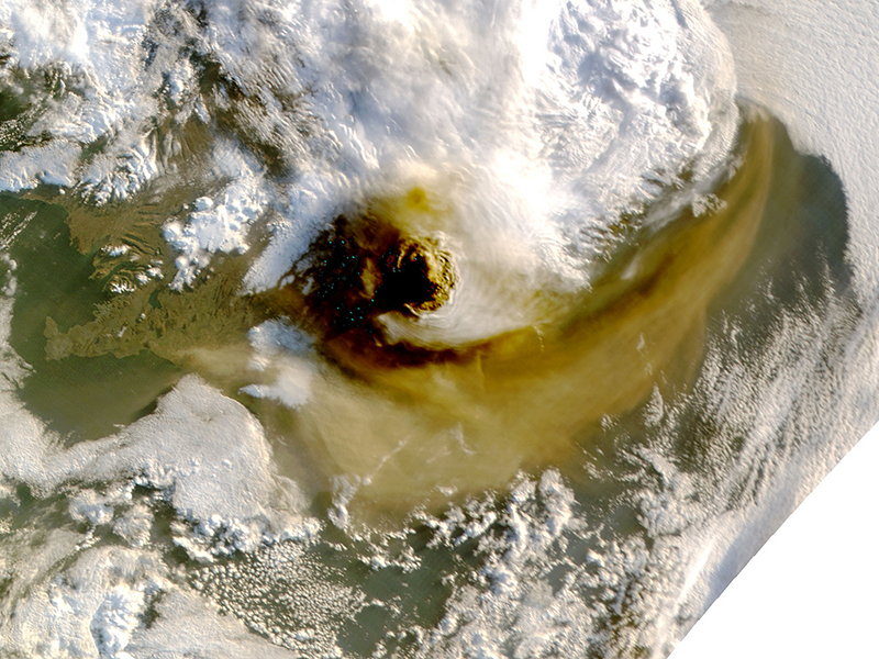 MODIS image of the 2011 eruption of GrÃ­msvÃ¶tn in Iceland, showing the brown ash plume swirling in the atmosphere. NASA.