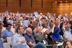 a group of astronomers voting with raised hands