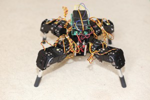 A four-legged black robot with exposed wires.